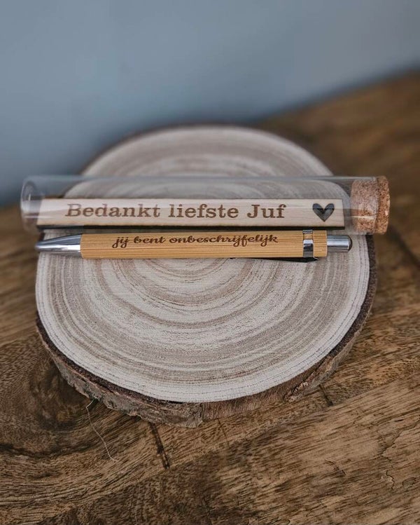 Buisje met pen en kleine boodschap op hout