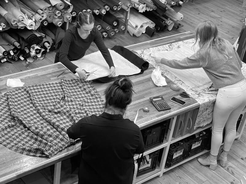 Cursisten aan de kniptafel tijdens de dinsdagavond naailessen