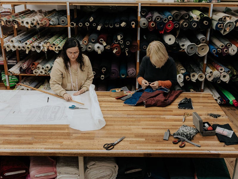 Cursisten aan de kniptafel tijdens de naailes op dinsdagavond