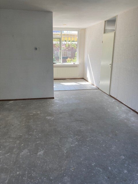 Lege kamer na woningontruiming met verwijderde vloerbedekking