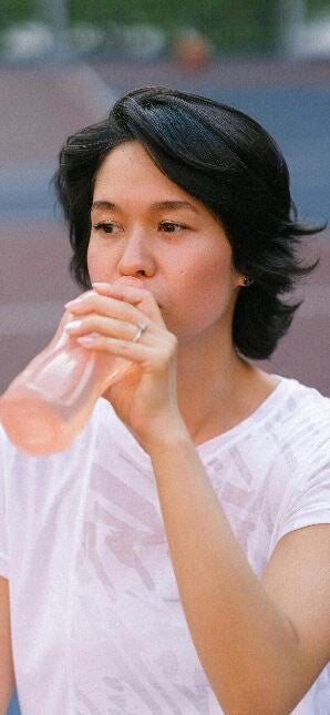 Femme qui s'hydrate en courant