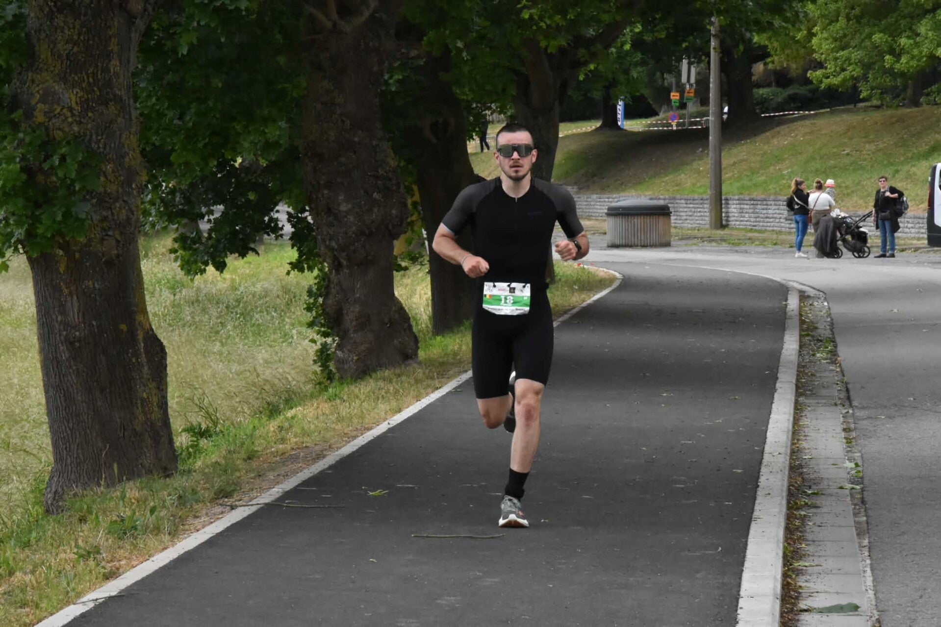 Athlète coaché sur le parcours de course à pied du Triathlon de Binche
