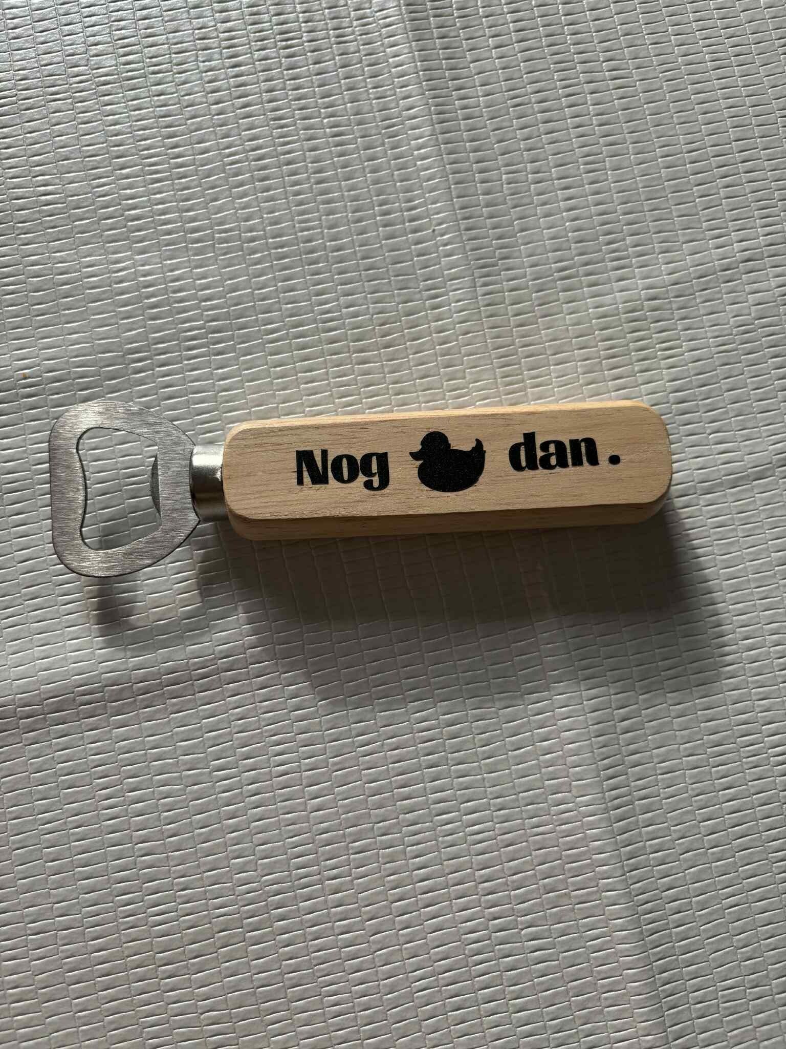 Houten opener met tekst.