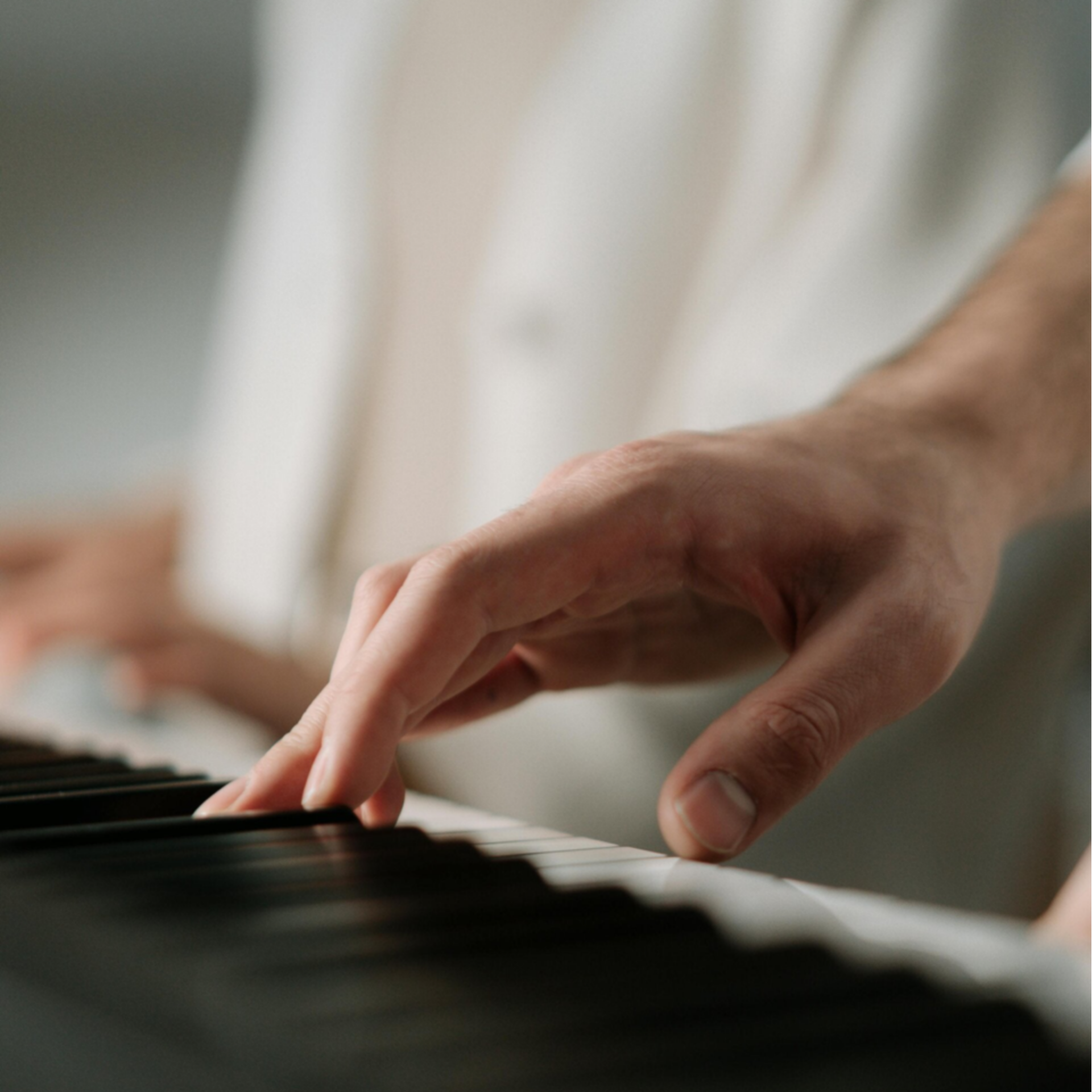 Piano teacher demonstrating hand technique on keys