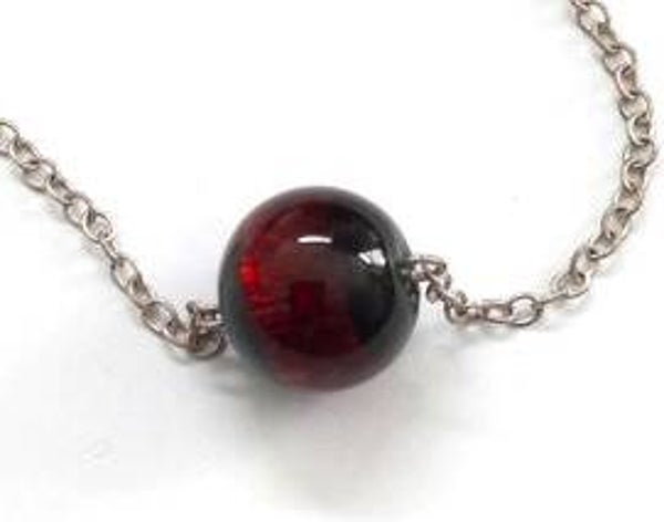 Rood glazen bolletje aan geïntegreerde ketting