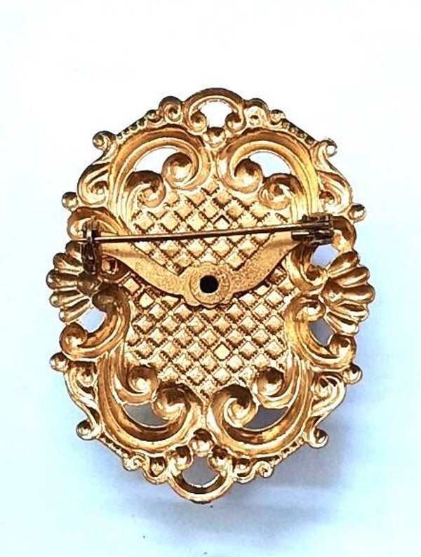 Goudkleurige ovale broche met grote zwarte facetsteen