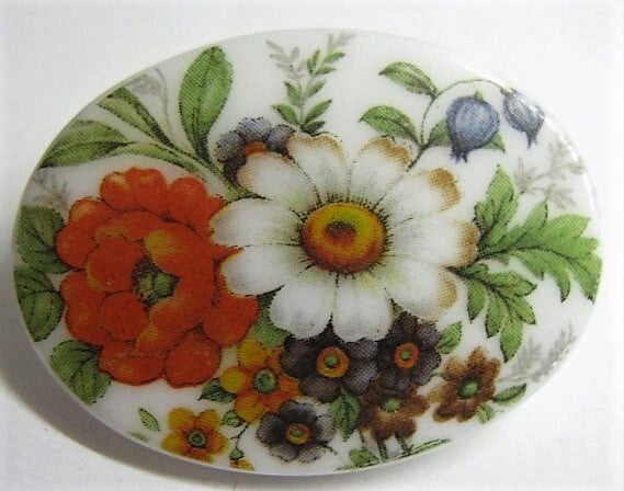Mooie bloemenbroche op wit ovaal glas (6067-1524)