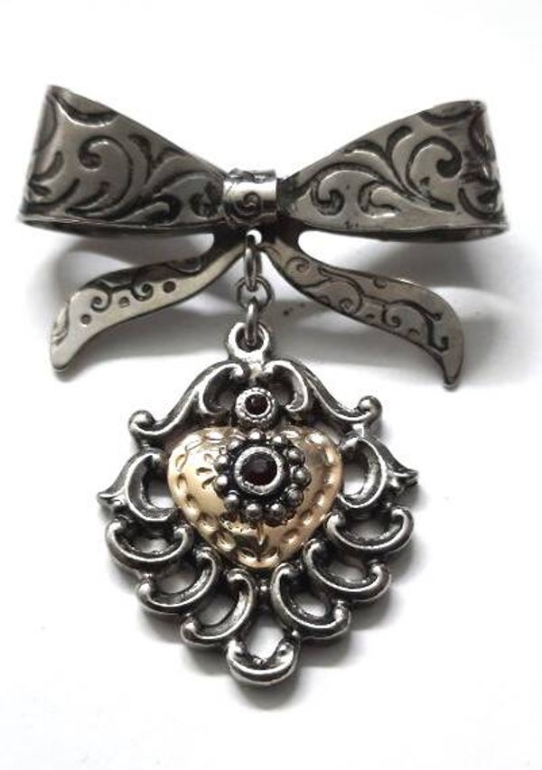 Zilverkleurige broche, strik met vergulde hanger met rode steentjes (6578-2018)