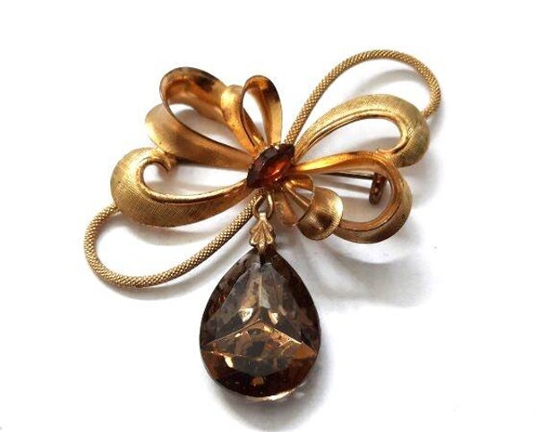 Prachtige vintage goudkleurige Strikbroche, Topaaskleurige Kristaldruppel (7900-4706)