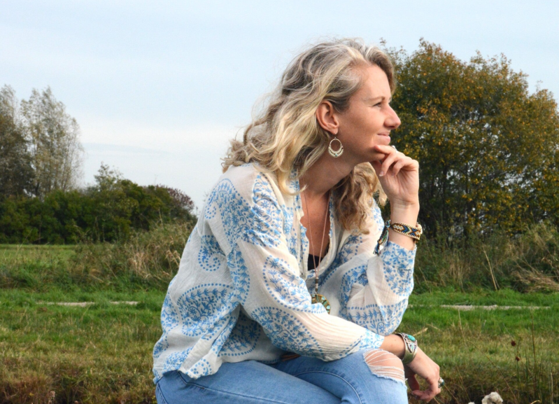 Holistisch coach Moniek Klop zittend in de natuur