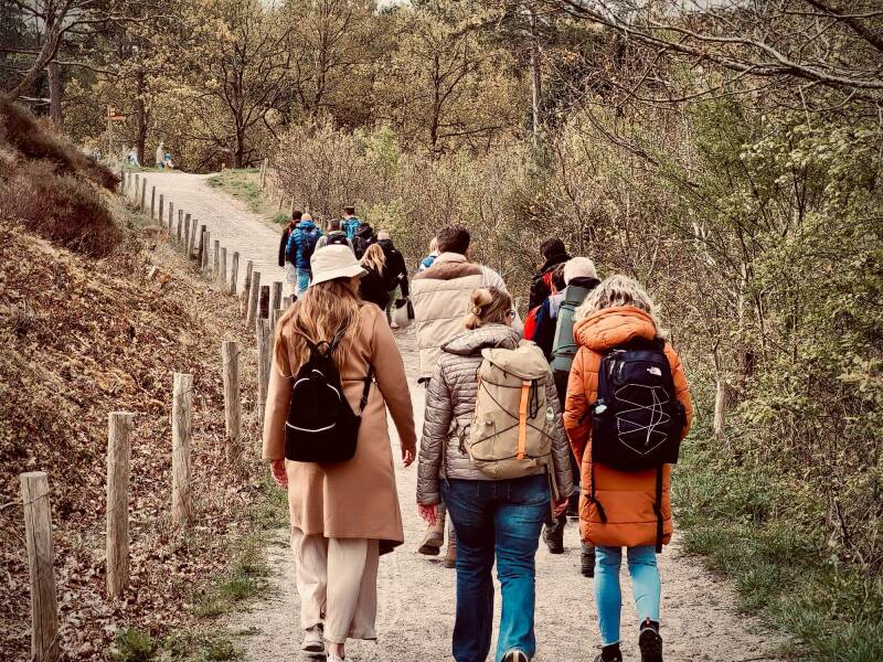 Een groepje mensen dat in het bos loopt in oprechte verbinding