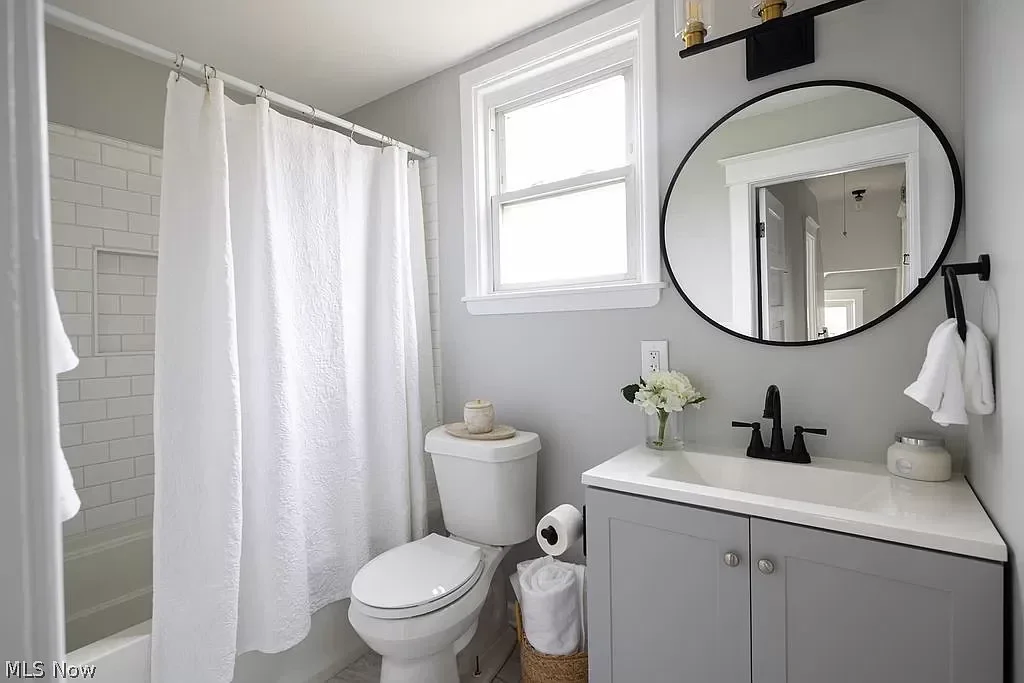 Warm and inviting bathroom remodel with natural wood tones, soaking tub, and elegant lighting