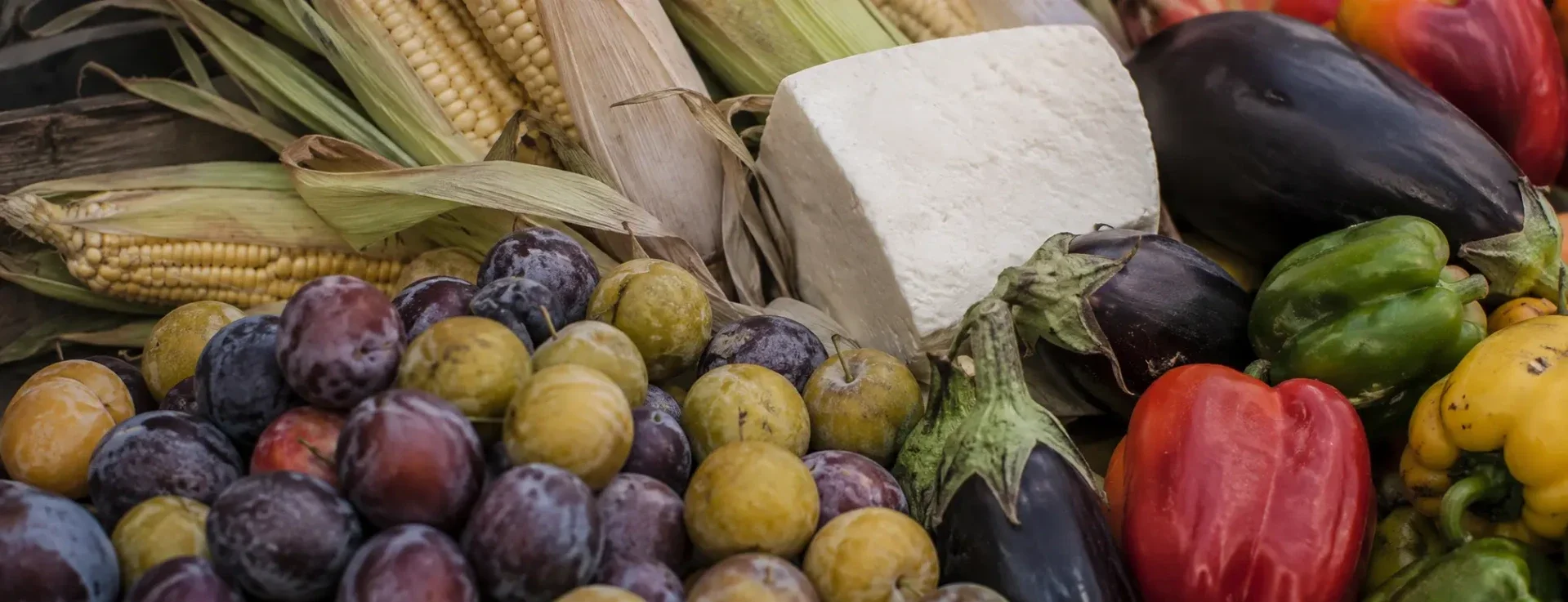 Fresh August seasonal produce and dairy from New Covent Garden Market in London, including British plums, sweetcorn, halloumi, aubergines and peppers, sourced by Flossies Fine Foods for London restaurants and cafes near Notting Hill.