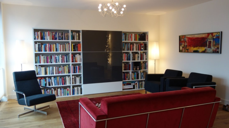 Lage boekenkast met TV ruimte achter schuifdeur