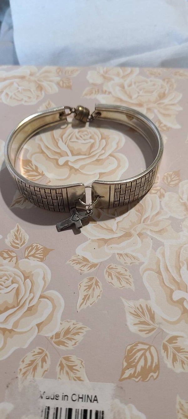 Basket weave bracelet with cross charm.