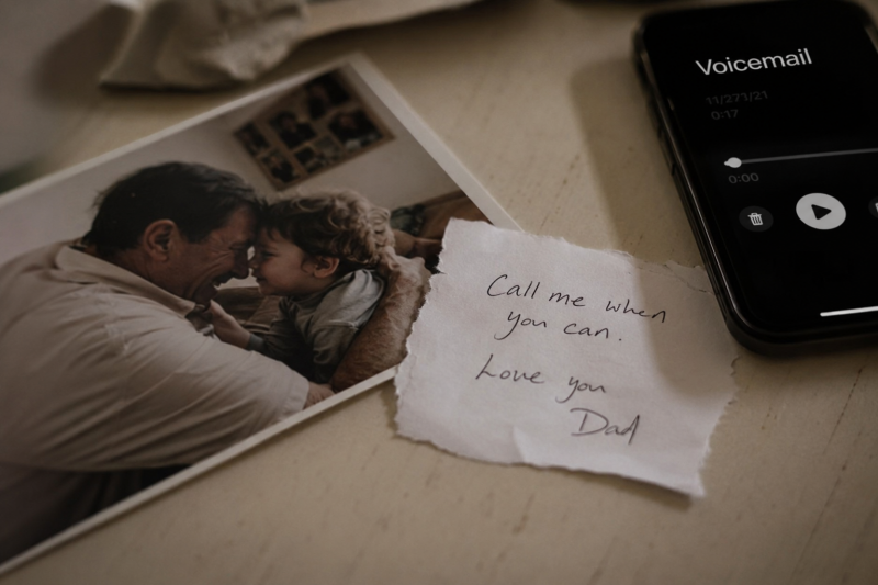 Old family photo beside a smartphone displaying a saved voicemail, symbolizing grief, remembrance, and preserving the voices of loved ones before they're gone.