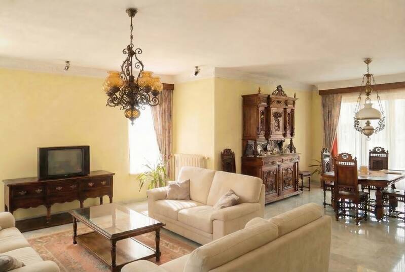 Gedateerde woonkamer met oude meubels die weinig aantrekkelijk oogt voor kopers