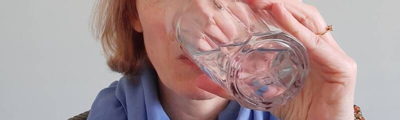 een vrouw drinkt een glas water