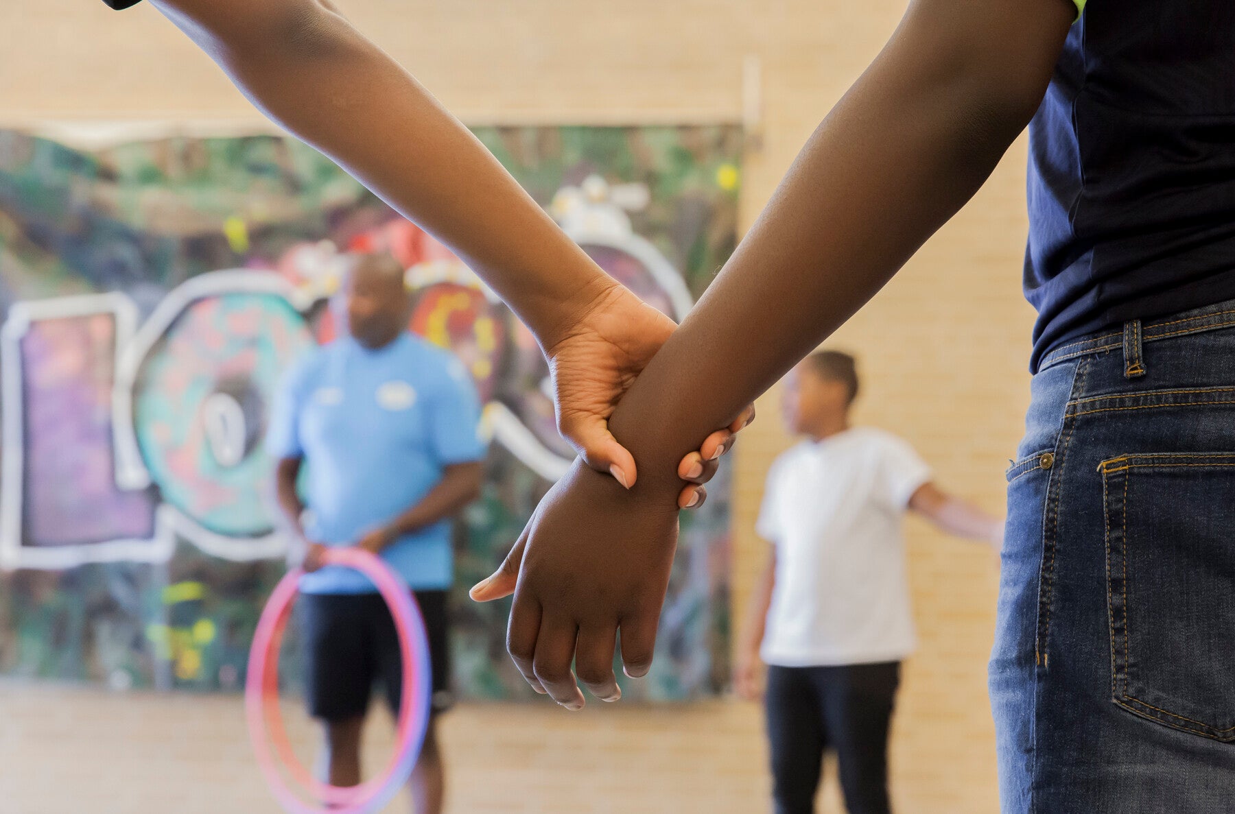 Tieners die tijdens een samenwerkingsopdracht elkaars handen vasthouden.