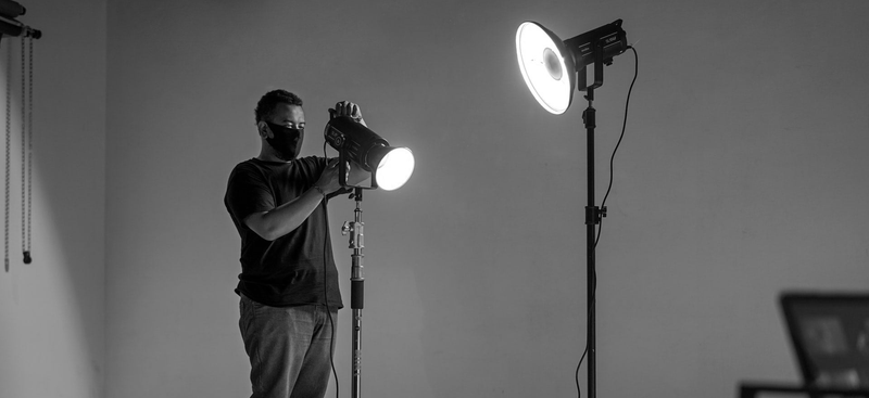 Mann stellt Scheinwerfer ein – Eventtechniker bei der Einrichtung professioneller Lichttechnik für Events von Eventglanz Krämer