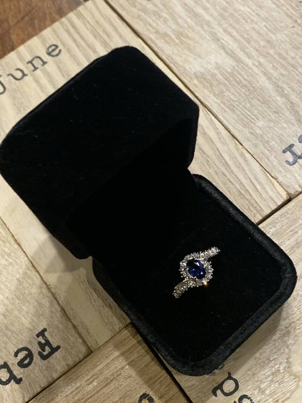 elegante verzilverde ring met safierkleurige steen rondom bezet met zirconia's