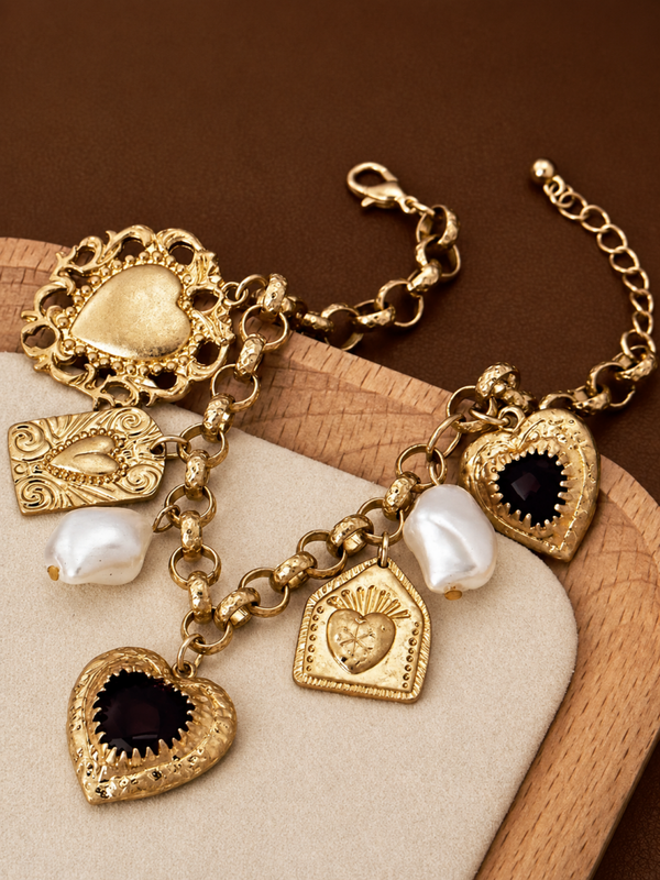 Goudkleurige bedelarmband met hartjes en parels