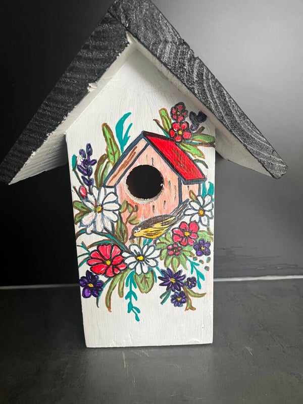 Vogelhuisje met kooitje en bloemen