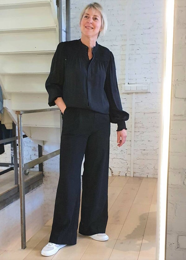 stijlvolle zwarte blouse met smokdetails aan mouwen en schouders