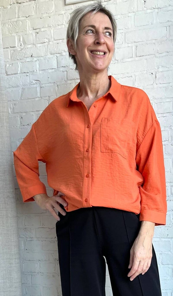 losvallende oranje blouse met 3/4 mouwen