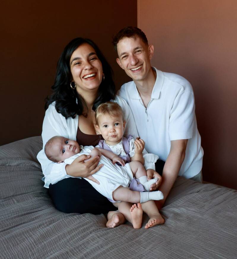 Gezin met peuter en pasgeboren baby samen op bed tijdens newbornshoot in Den Haag
