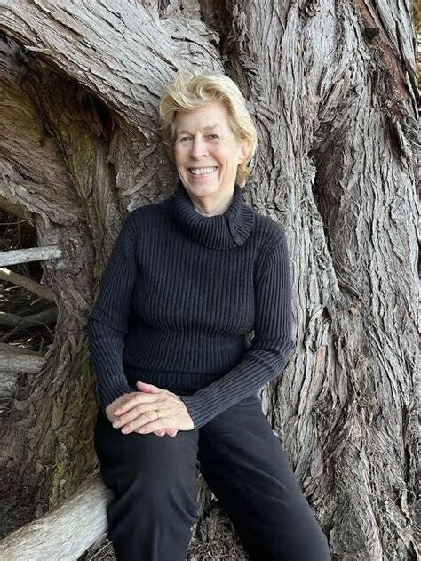 Author Alison Owings smiles while leaning against a tree