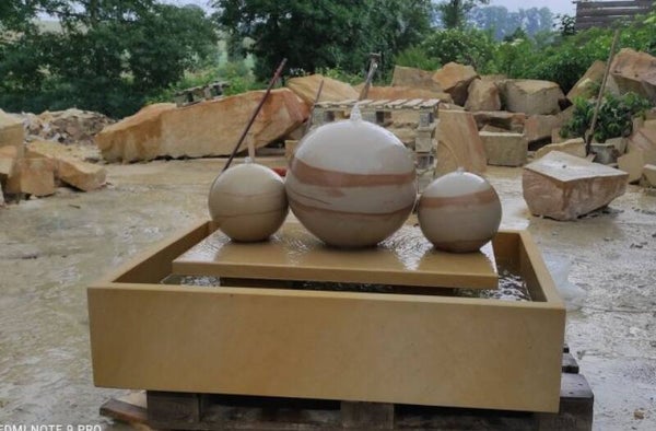 Set aus einem Brunnen mit drei Sandsteinkugeln