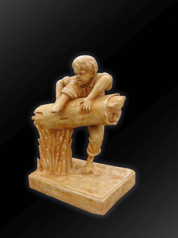 Skulptur Jungen auf einem Baumstamm darstellt