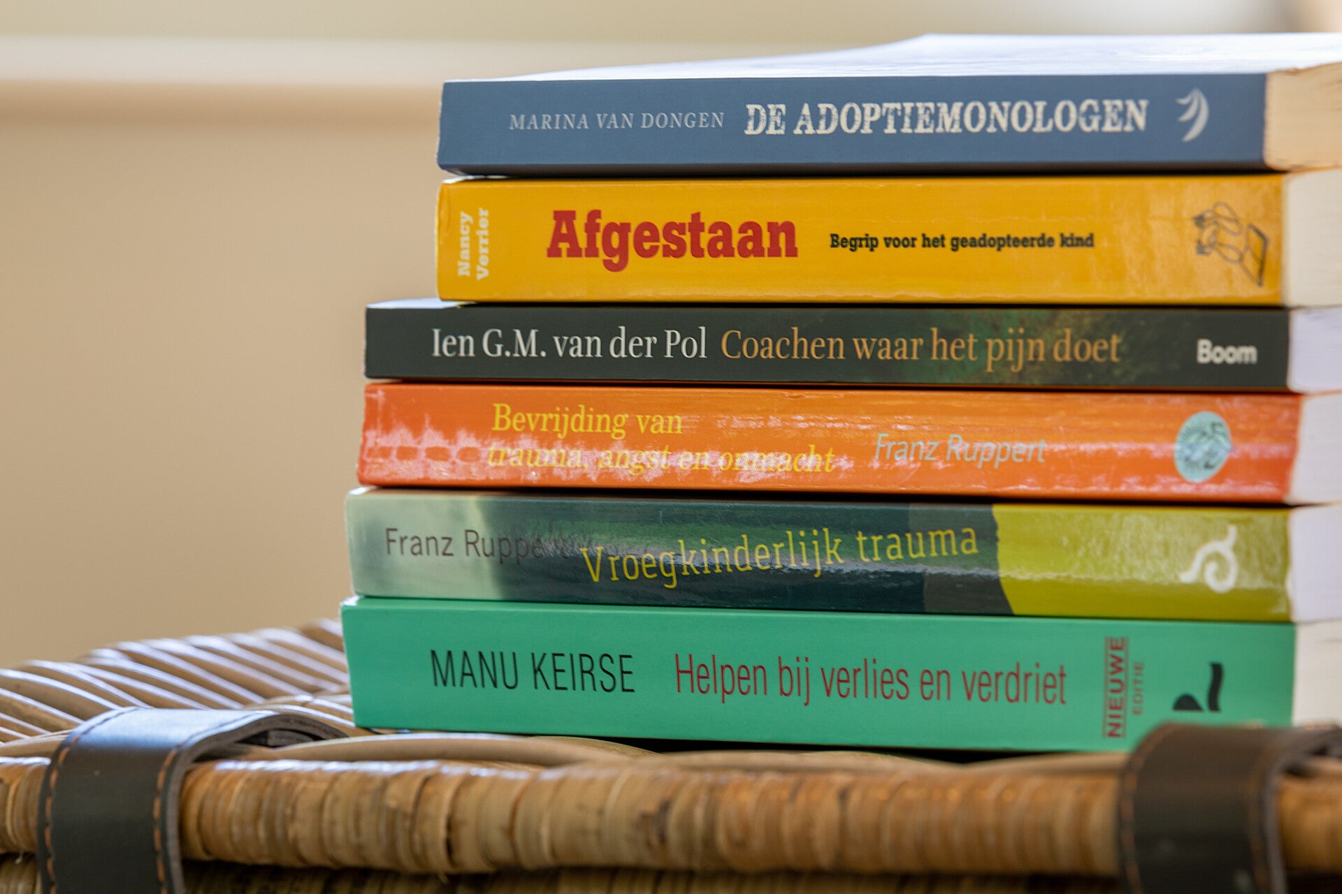 Stapeltje boeken over coaching, trauma, verlies en persoonlijke ontwikkeling – symbolisch voor deskundigheid en voortdurende professionele groei van de therapeut.