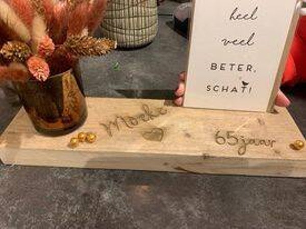 plank met kaartje en druk op de plank