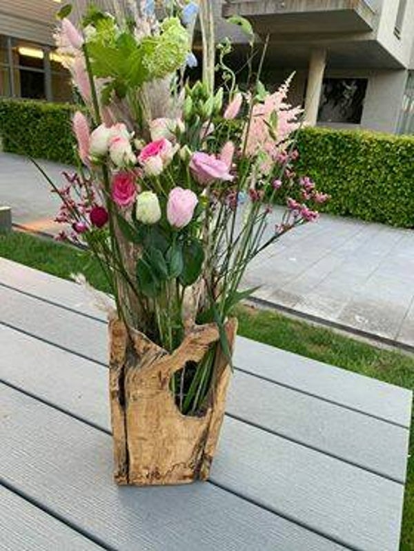 hoge vaas met exotix hout opgevuld met veldbloemen