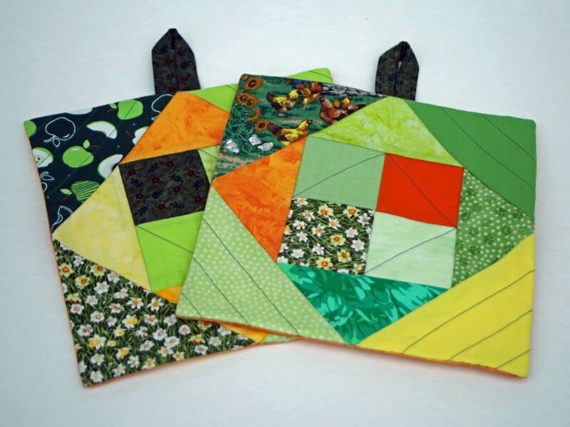 Et sæt grydelapper i patchwork - bagsiderne er ens, forsiderne forskellige 21x21cm   175 kr.