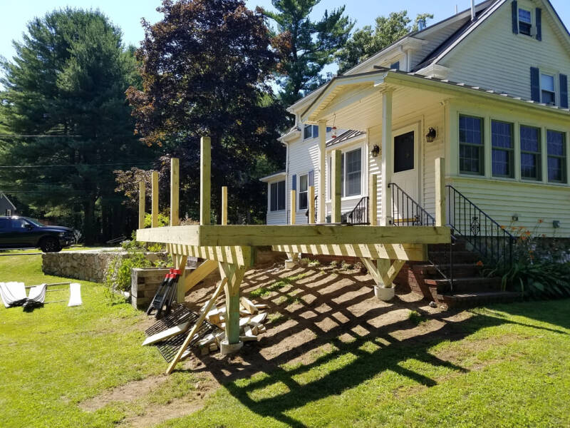 Deck construction showing joists, framing, and early-stage structural work.