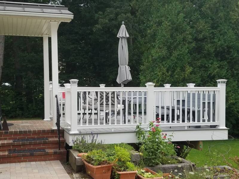 Finished deck with composite boards and arranged seating for outdoor use.