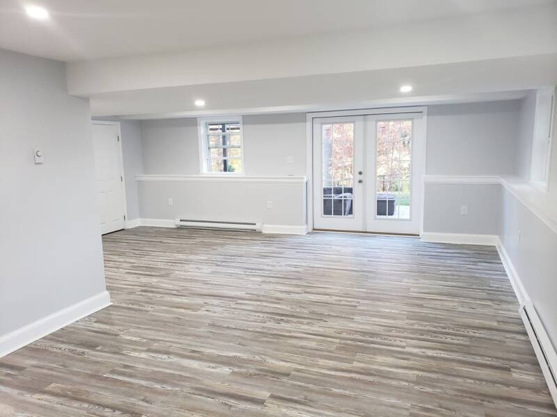 Finished basement with new flooring, recessed lighting, and an open living area.