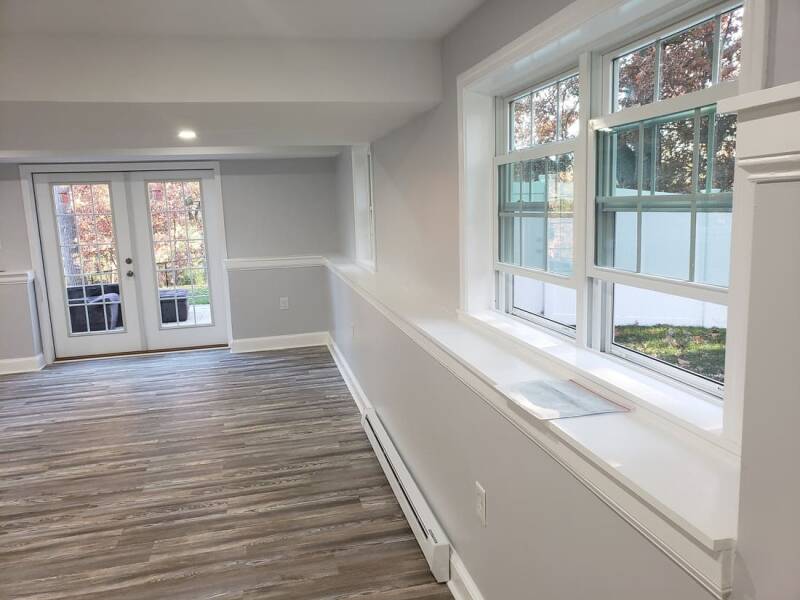 Renovated basement featuring smooth walls, updated flooring, and bright recessed lighting.