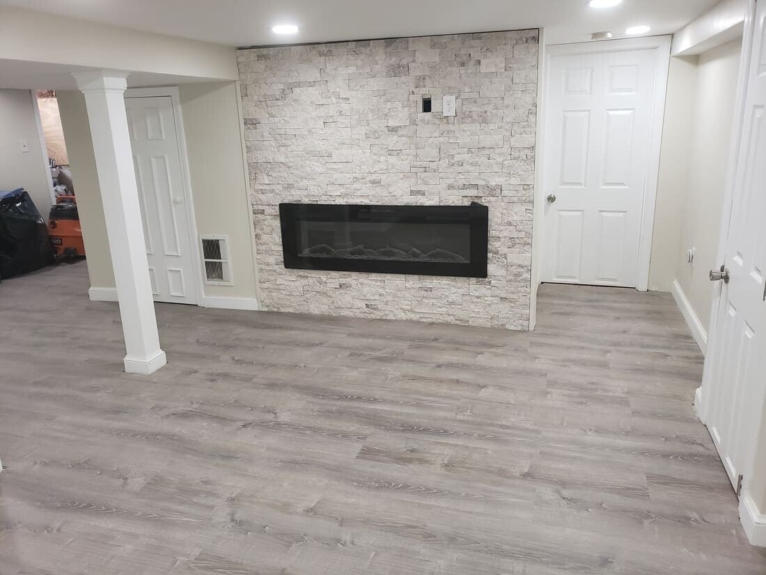 Renovated basement with clean walls, updated flooring, and modern lighting.
