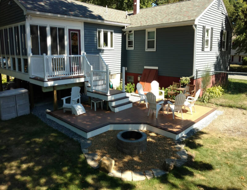 Completed backyard deck with comfortable seating, a stone firepit, and a dedicated hot tub area.