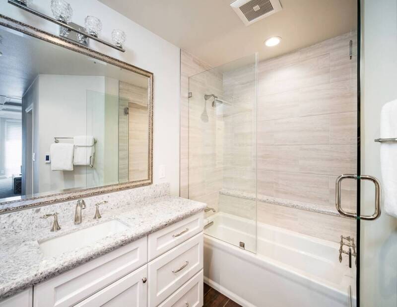 Remodeled bathroom featuring a new vanity, fresh tile work, and bright lighting.