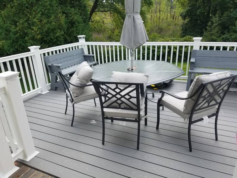 Gray composite deck with outdoor table and chairs arranged for seating.