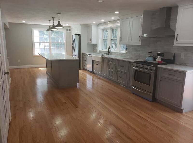 Renovated kitchen showing new cabinetry, bright lighting, and a clean open layout.