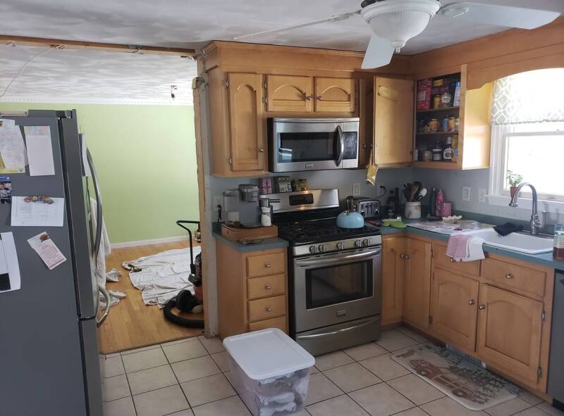 Kitchen remodel in progress with cabinets removed and construction materials visible.