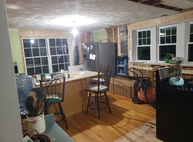 Kitchen renovation showing exposed walls, electrical work, and ongoing updates.