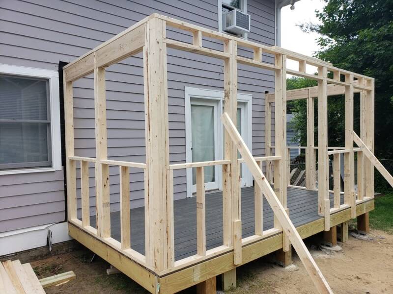 Home addition framing in progress with wall studs and structural layout visible.