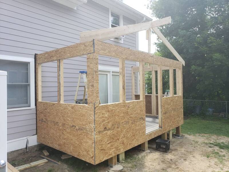 Construction stage of the addition with window openings prepared and exterior work underway.